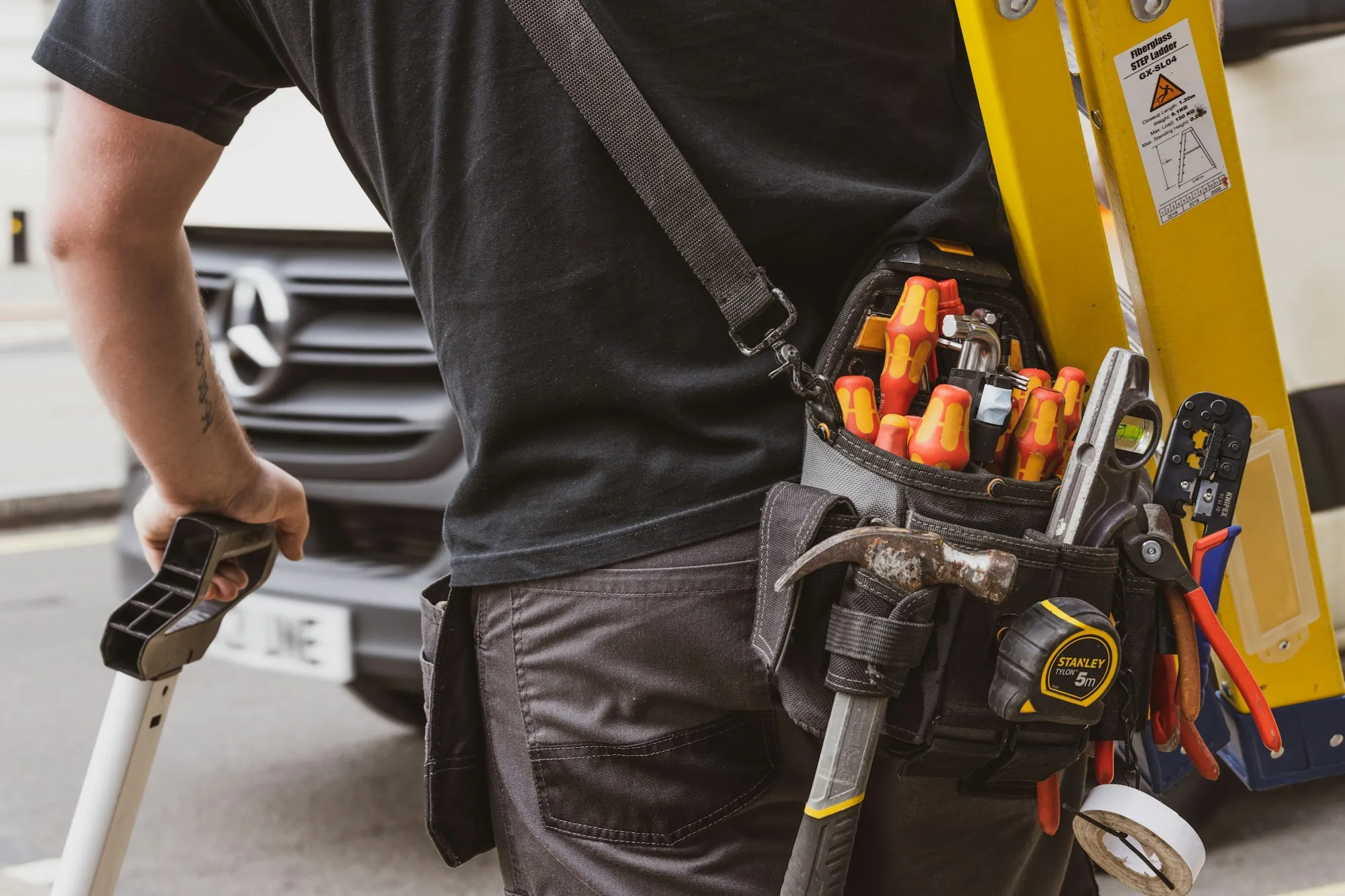 Technician tool belt packed with screwdrivers and pliers